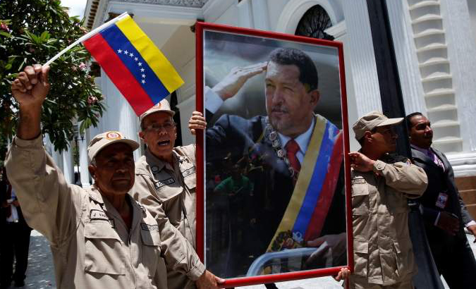 A man holds a portrait of late Venezuelan President Hugo Chavez during a rally in Caracas.