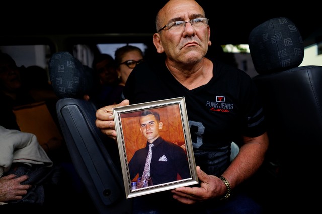 Mario Santos shows a picture of his late son Carlos Santos, who was killed in the Boeing 737 plane crash, as he leaves a funeral parlor in Havana.