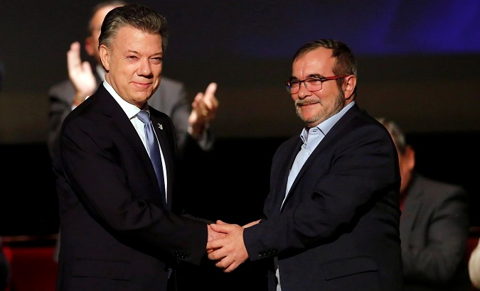 Colombia's President Juan Manuel Santos and FARC leader Rodrigo Londono shake hands after signing a peace accord in Bogota, Colombia November 2016.