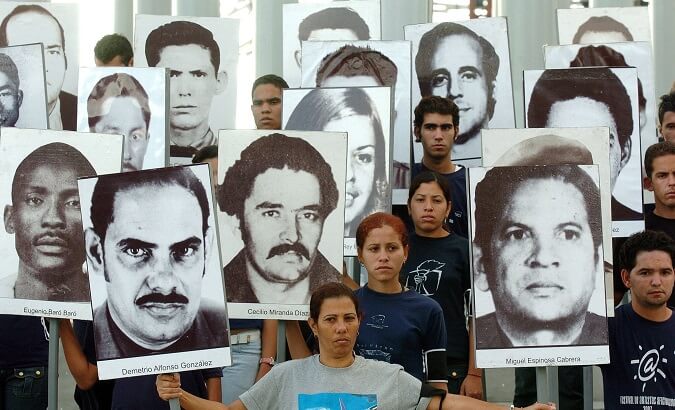 Cubans carry portraits of Posada Carriles' victims.