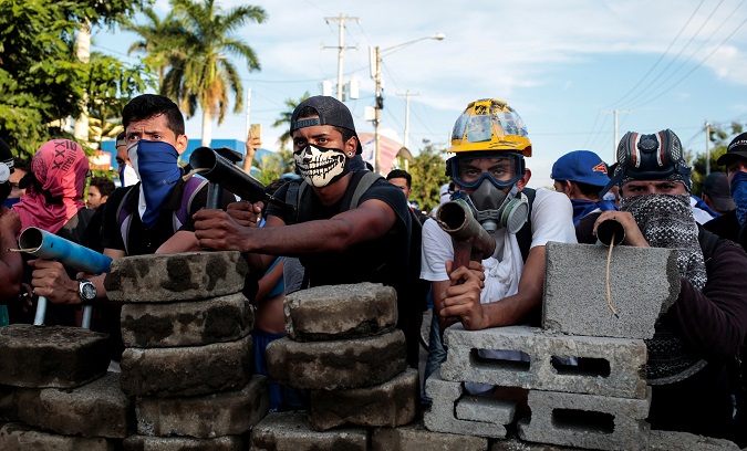 Demonstrators stand behind a barricade during clashes with riot police during a protest against Nicaragua's President Daniel Ortega's government in Managua, Nicaragua May 30, 2018.