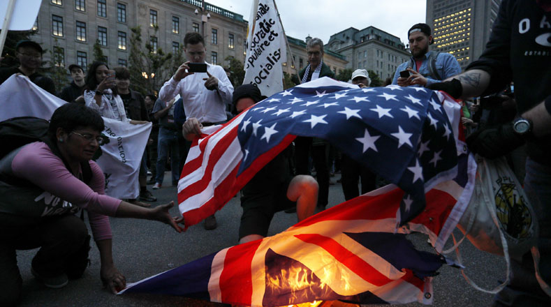 Ciudadanos incendian la banderas de Estados Unidos y el Reino Unido durante las marchas contra el G7