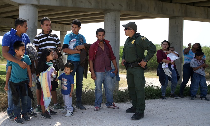 Border patrol agent Sergio Ramirez talks with immigrants who illegally crossed the border from Mexico into the U.S. in the Rio Grande Valley sector, near McAllen, Texas, U.S., April 2, 2018.