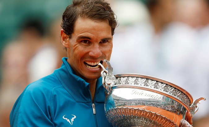 Spain's Rafael Nadal celebrates by biting the trophy of the French Open after winning the final against Austria's Dominic Thiem