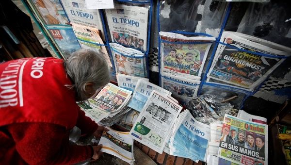 A woman sells newspapers that show candidates Gustavo Petro and Ivan Duque go to the second round of presidential election, in Bogota, Colombia May 28, 2018.