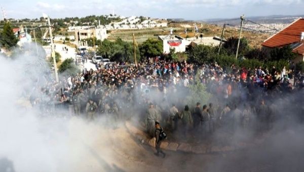 Israeli forces face Jewish settler protesters during a court-ordered demolition on Palestinian-owned land.