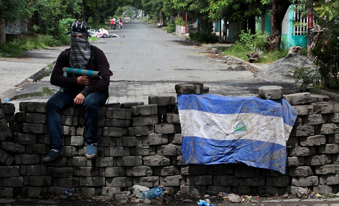 A man holding a homemade mortar sits on a roadblock in Managua, Nicaragua June 16, 2018.