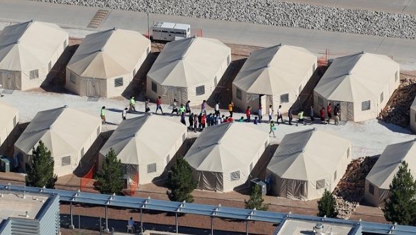 Immigrant children are shown walking in single file between tents in their compound next to the Mexican border in Tornillo, Texas, U.S. June 18, 2018.