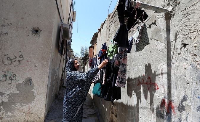 A Palestinian woman hangs laundry outside her house at Khan Younis refugee camp in the southern Gaza Strip June 20, 2018.