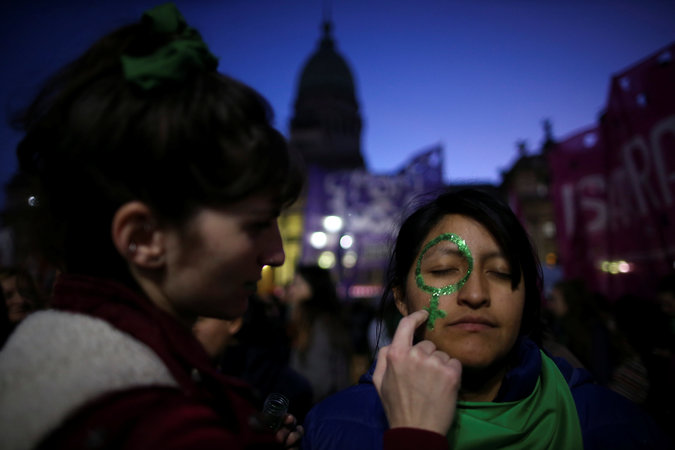 A woman has her face painted during the demonstration