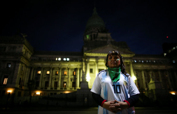 A woman wearing an Argentine national soccer shirt posing during the protest