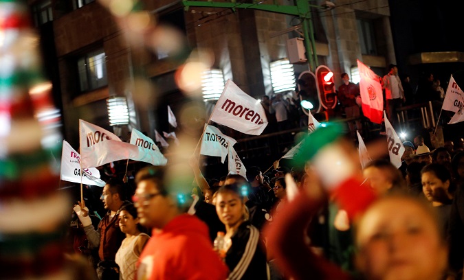 Supporters of Mexico's President-Elect Andres Manuel Lopez Obrador carry the flags of his political party, Morena.