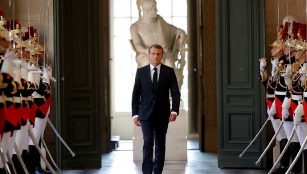 French President Emmanuel Macron walks through the Galerie des Bustes (Busts Gallery) to access the Versailles Palace's hemicycle.