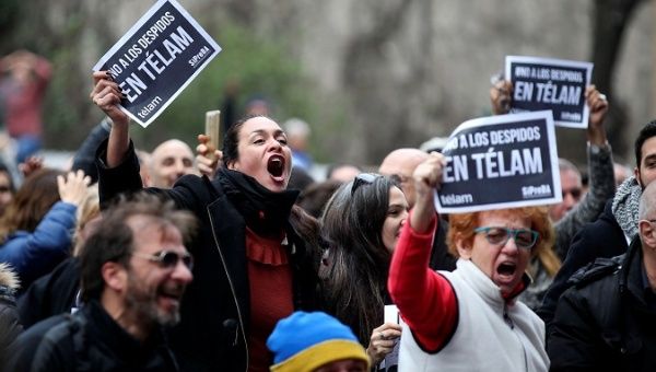 Workers of the Argentina's state news agency Telam react during the broadcast of the match between Argentina and France in Buenos Aires, Argentina, June 30, 2018. The bplacards read: 