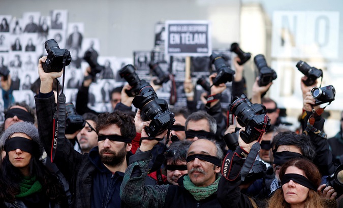 Blindfolded journalists protest the layoff of 300 workers of Argentina's public network, Telam.
