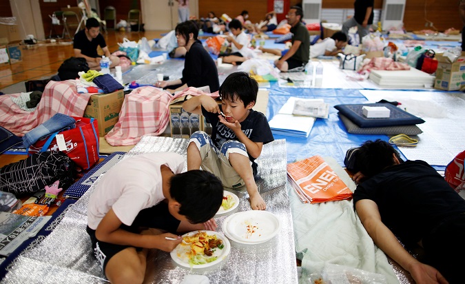 Evacuee Miyo Takeuchi, 7, eats a meal with her family at Okada elementary school, which is acting a temporary shelter for flood victims in Mabi town in Kurashiki, Okayama Prefecture, Japan, July 12, 2018.
