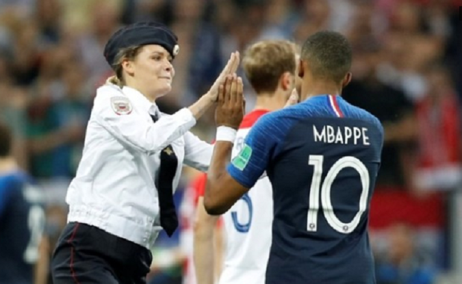 One photograph on social media showed one of the pitch invaders, a woman with blonde hair tucked under a police cap, performing a high-five with France player Kylian Mbappe before being caught.
