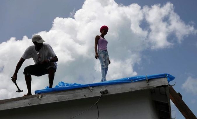 Devon Warner and his daughter Che Niesha work on the roof in Barbuda.