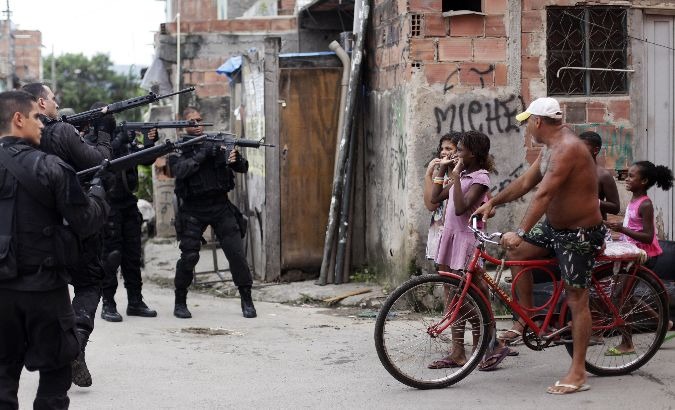 Policemen brandish their weapons in Complexo da Mare favelas in Rio de Janeiro, Brazil.