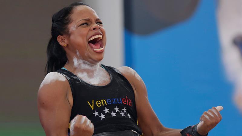 La pesista Génesis Rodríguez, deportista de Venezuela, celebra efusivamente al terminar un intento en la prueba de levantamiento de pesas.