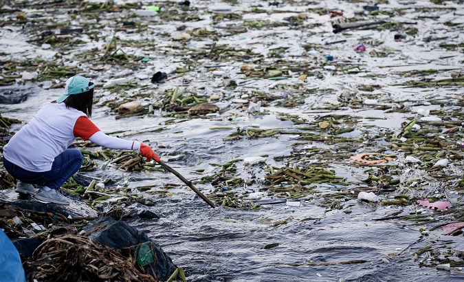 A volunteer searches for plastic on International Coastal Clean-up Day in Manila Bay, Philippines, September 2017.