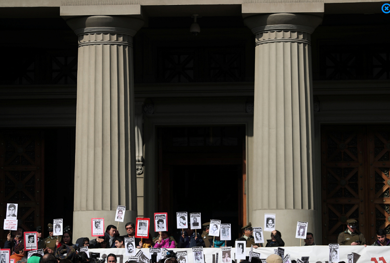 Human rights activists hold images of missing people during a protest against the decision of the Supreme Court to grant parole to human right abusers during Chilean dictatorship, in Santiago, Chile August 1, 2018.