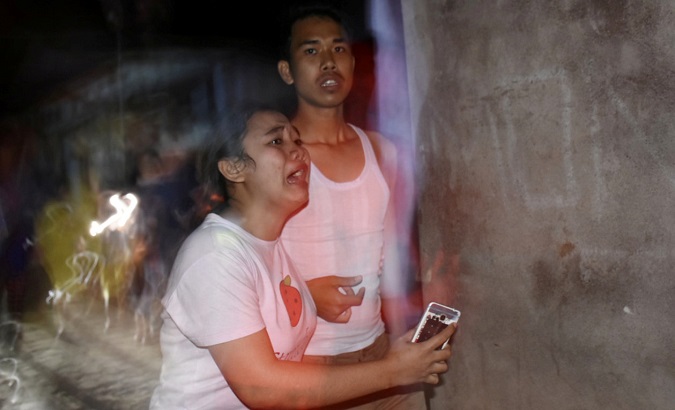 People react following an earthquake in Ampenan district, Mataram, Lombok.