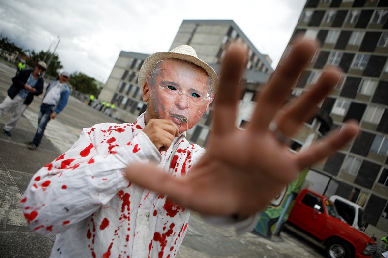 A protester wears a mask of former President Alvaro Uribe and a bloodied shirt. Uribe is expected to play an important role in the Duque government.
