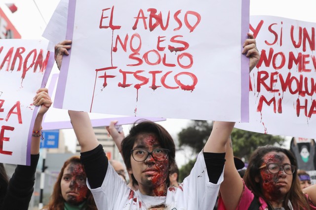 A demonstrator holds a sign saying 
