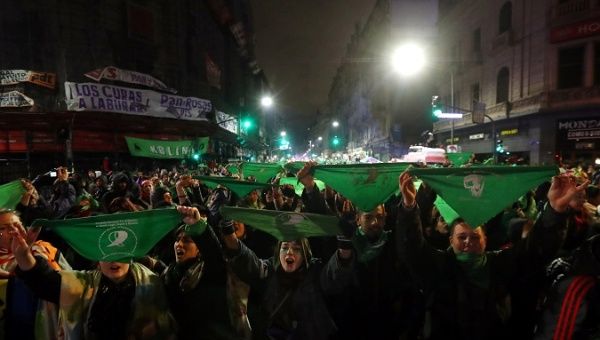 Activists hold up green handkerchiefs outside the Congress after senators rejected a bill to legalize abortion in Buenos Aires