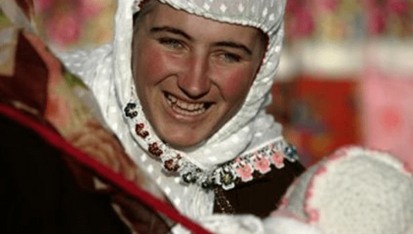 A Bulgarian Muslim woman smiles as she plays with a baby during a wedding ceremony in the village of Ribnovo, in the Rhodope Mountains, November 19, 2006 .