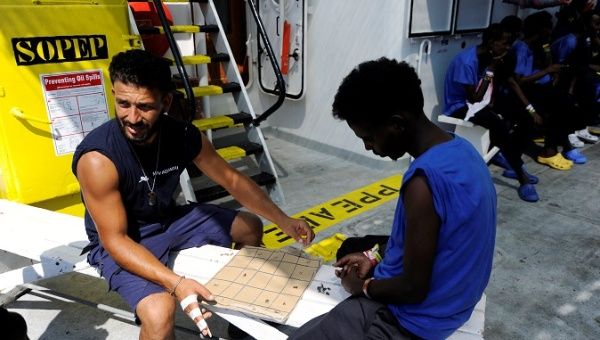 A member of SOS Mediterranee plays chess with a migrant on board the MV Aquarius, in the Mediterranean Sea, between Malta and Linosa, August 14, 2018