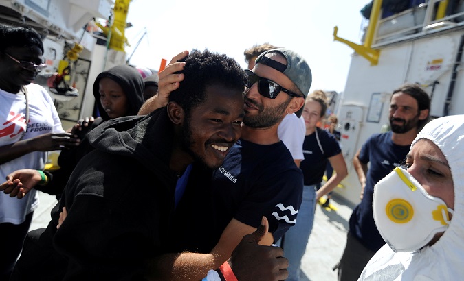 A migrant smiles before disembarking from the MV Aquarius in the harbour of Valletta, Malta, August 15, 2018.