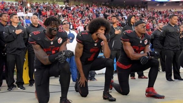 San Francisco 49ers outside linebacker Harold, quarterback Kaepernick and free safety Reid kneel in protest during the playing of the national anthem in 2016.