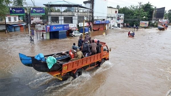 A supply truck transporting boats to flooded areas moves through a water-logged road in Aluva in the southern state of Kerala, India, August 18, 2018.