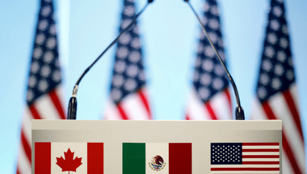 The flags of Canada, Mexico and the U.S. on a lectern before a joint news conference on the closing of the seventh round of NAFTA talks in Mexico City, Mexico, March 5, 2018