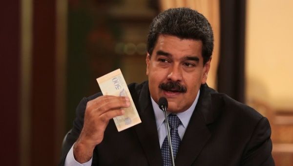 Venezuela's President Nicolas Maduro holds a bank note from the new Venezuelan currency Sovereign Bolivar at Miraflores Palace in Caracas, Venezuela.