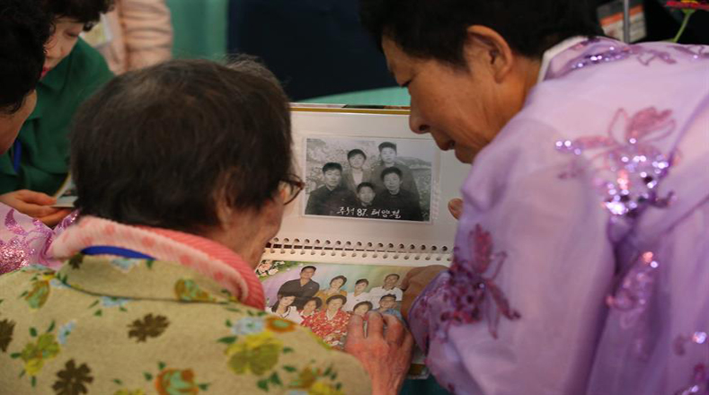 La surcoreana Han Shin-ja, de 99 años; y su hija, residente en Corea del Norte, Kim Kyung-yeong, de 71 años; observan viejas fotografías en las que aún no eran golpeadas por la distancia.