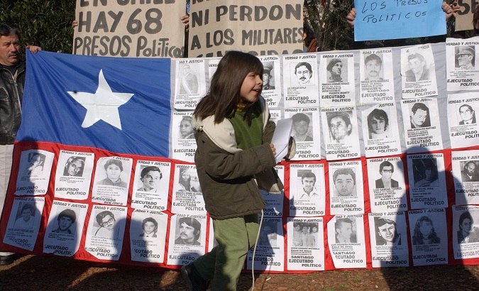 A Chilean flag featuring victims of the dictatorship on the anniversary of the coup that brought Pinochet to power, 2003.