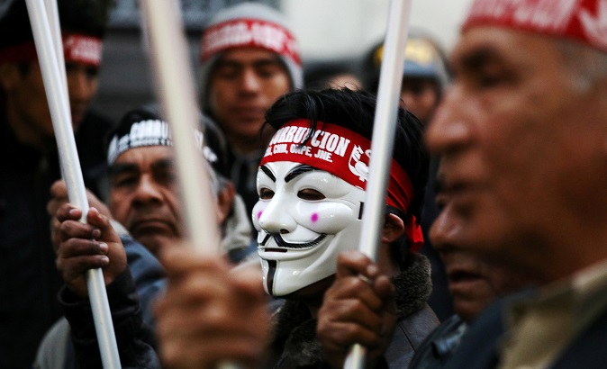 A protester wearing a Guy Fawkes mask marches against influence-peddling scandal involving judges, prosecutors, politicians and businessmen.
