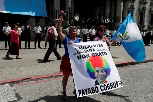 Women hold a banner showing Guatemala's President Jimmy Morales as a clown during a protest to demand his resignation in Guatemala City, Guatemala September 12, 2018. 