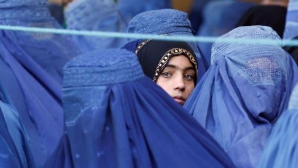 A girl looks on among Afghan women lining up to receive relief assistance in Jalalabad, Afghanistan, June 11, 2017. 