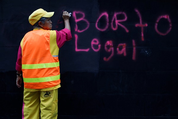 An employee cleans grafitti reading 