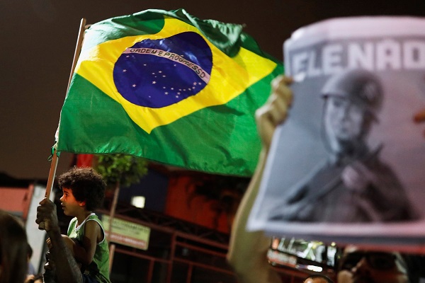 The Brazilian flag alongside an 'Ele Nao' banner featuring the candidate dressed up as a military officer in Sao Paulo.