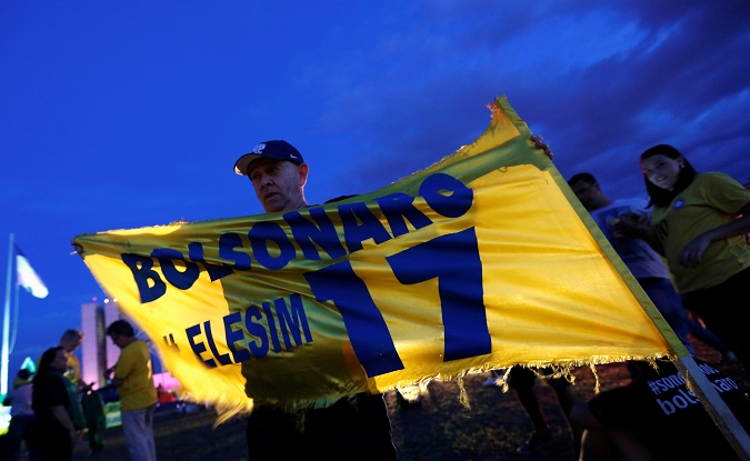 A supporter of Jair Bolsonaro, far-right lawmaker and presidential candidate of the Social Liberal Party (PSL), holds a banner, in Brasilia, Brazil October 7, 2018.