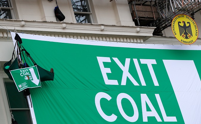 A Greenpeace activist hangs from ropes after deploying a banner against coal outside Germany's embassy in London, Britain, October 8, 2018.