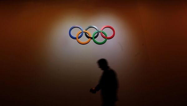 A man walks past the Olympic rings as he walks out of the 133rd IOC session in Buenos Aires.