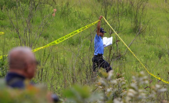 A police officer cordons off a clandestine cemetery discovered in El Lolo neighborhood, on the outskirts of Tegucigalpa, Honduras, July 21, 2017.