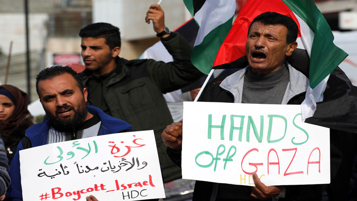 Palestinos sostuvieron pancartas y banderas nacionales el martes durante una protesta solidaria por Gaza.