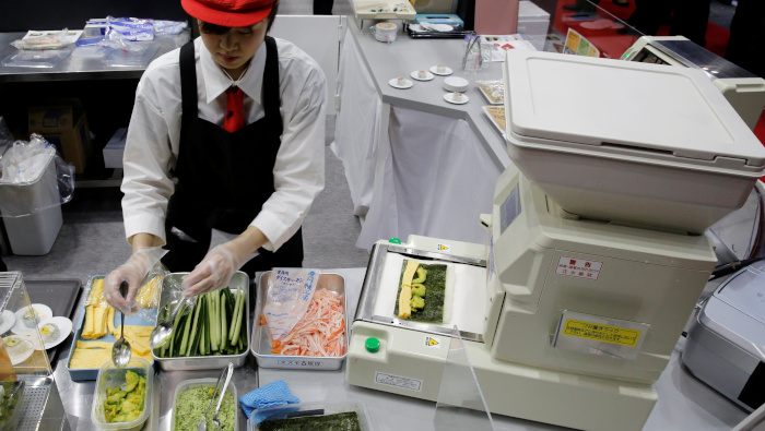 Una mujer hace rollos de sushi en un evento en Tokio, Japón.